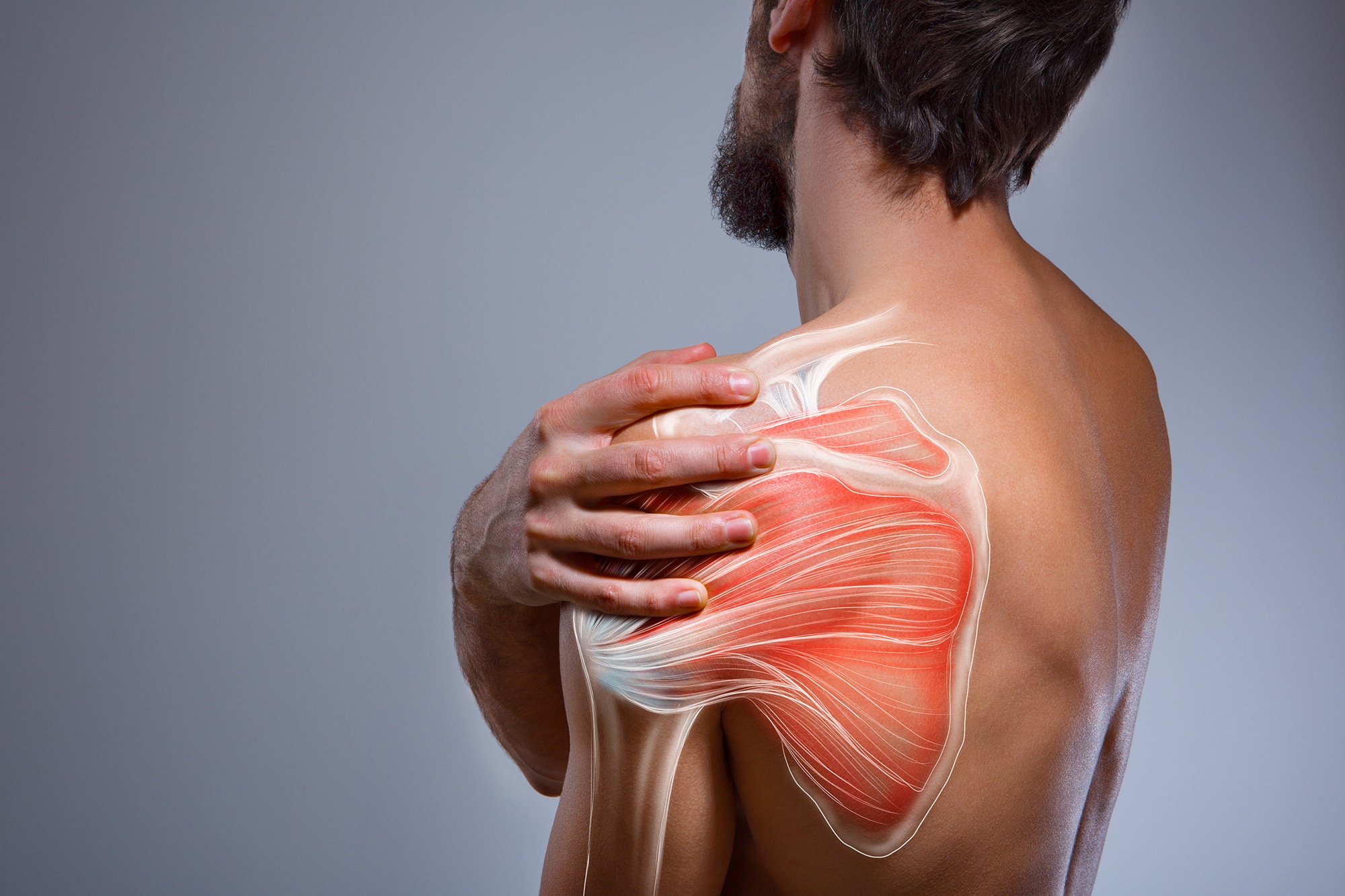 man holding shoulder in pain - needs a deep tissue massage for shoulder pain