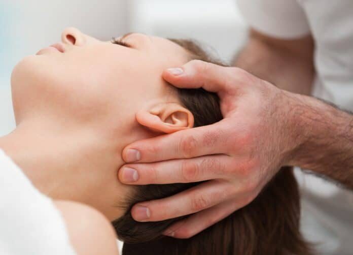 woman receiving a cranial sacrum therapy massage by doctor in white