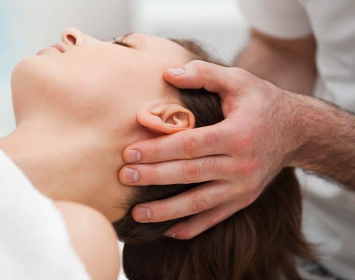 woman receiving a cranial sacrum therapy massage by doctor in white