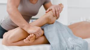thai massage therapist stretching a patient 