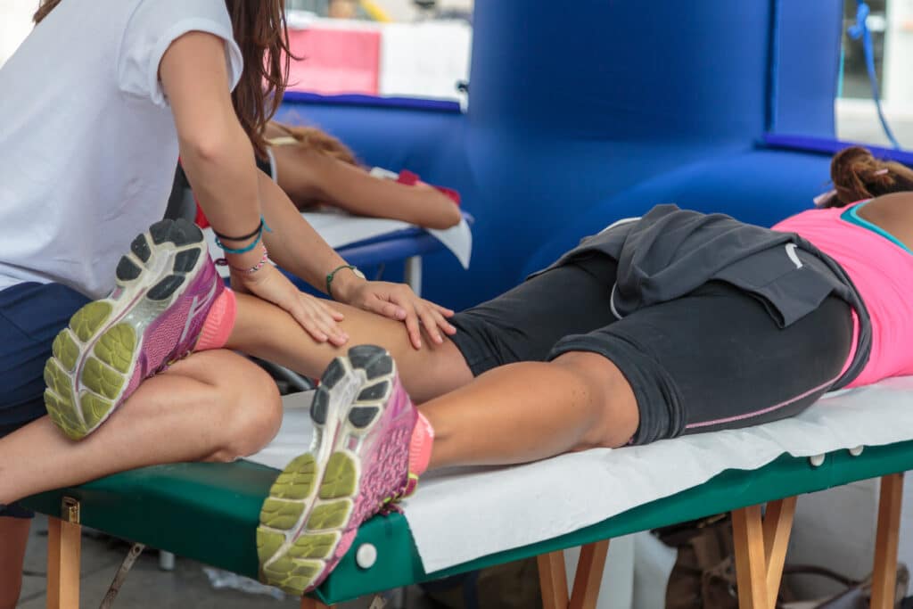 sports massage therapist giving a pre-event sports massage to a athlete
