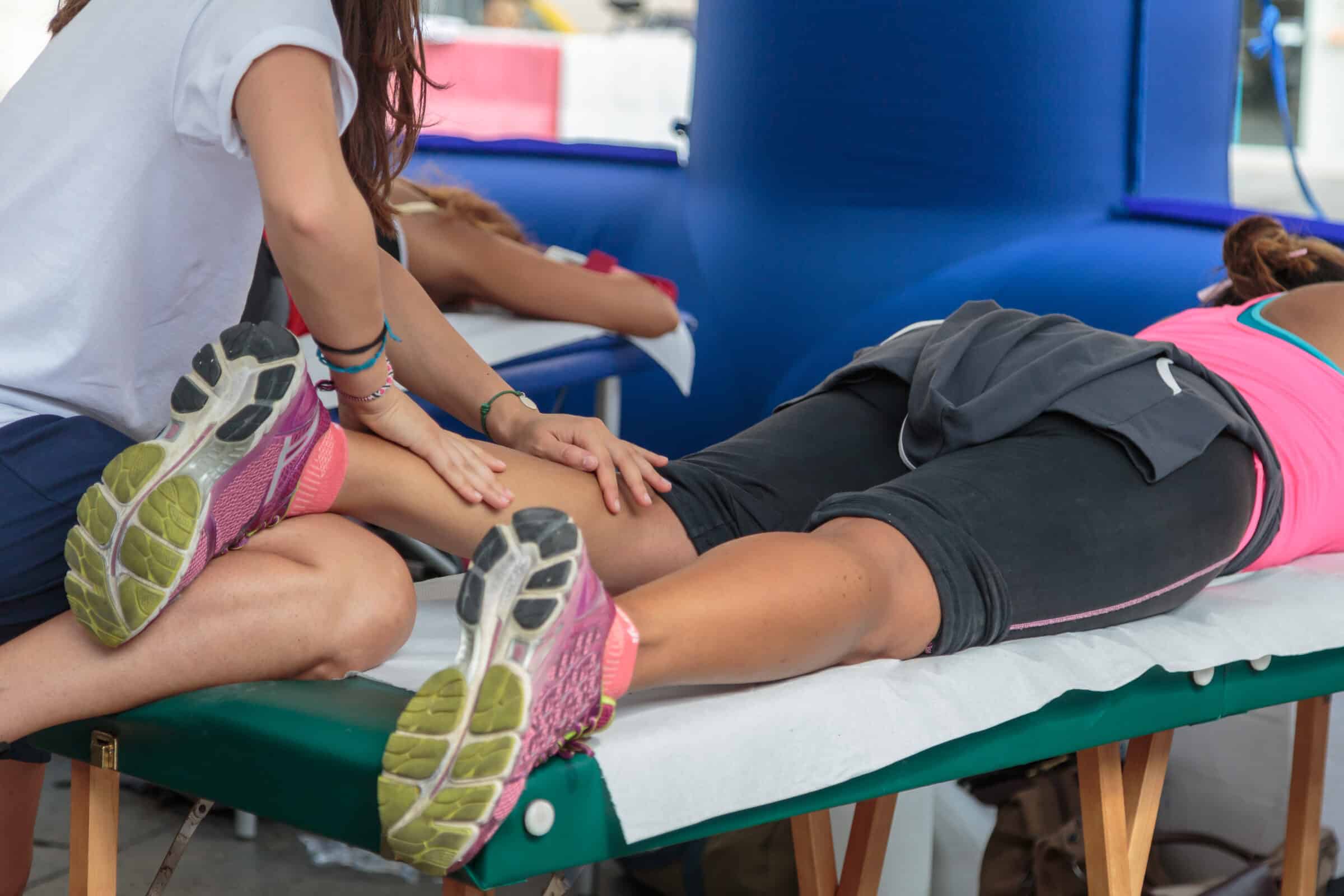 sports massage therapist giving a pre-event sports massage to a athlete