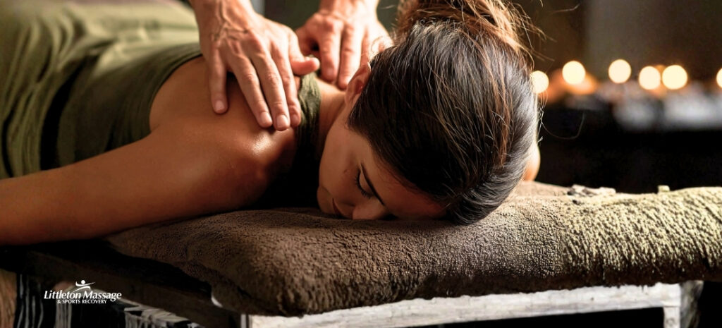 Client receiving a neuromuscular massage focused on the upper back, targeting muscle tension and chronic pain at the source.